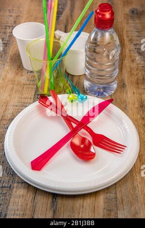 Plastikmüll, verschiedene Plastikutensilien, Umweltschutz auf Holzhintergrund Stockfoto