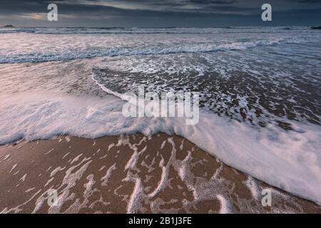 Ankommende Wellen an einem kalten kühlen Abend am Fistral Beach in Newquay in Cornwall. Stockfoto