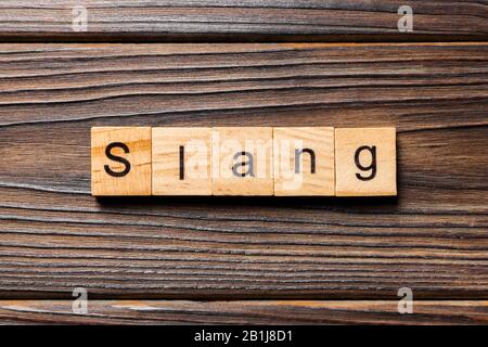 Slang Word auf Holz Block geschrieben. slang Text auf Tisch, Konzept. Stockfoto