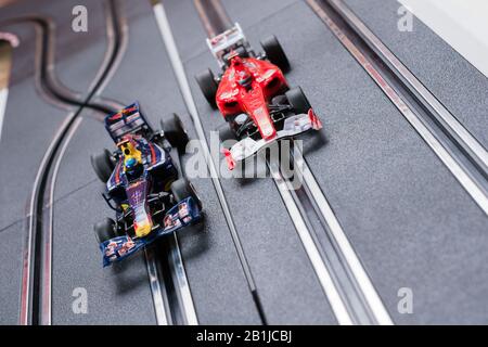 Modell Formel 1 Redbull und ein Ferrari Style Slot Cars, die auf einer Scalextric-Strecke Rennen Stockfoto