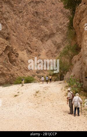 Menschen, die auf einem Weg im Wadi Shab in Oman spazieren gehen Stockfoto