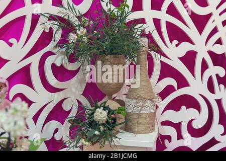 Tischmitte mit Hochzeitsdekor und Weinflaschen Stockfoto