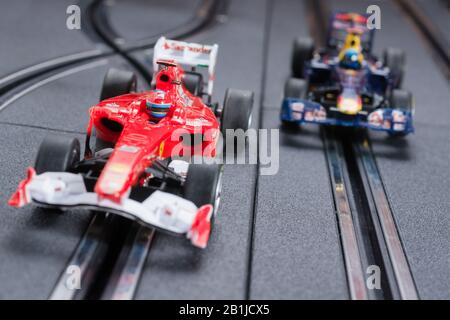 Modellformel eins Ferrari- und Redbull-Slot-Autos, die auf einer Scalextric-Strecke Rennen Stockfoto