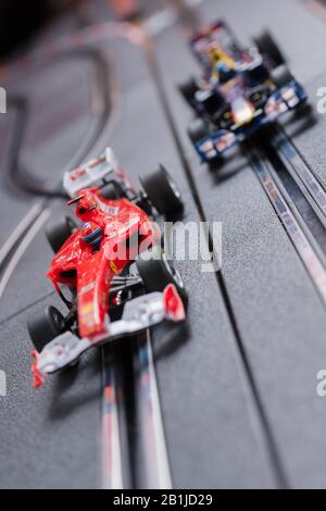 Modellformel eins Ferrari- und Redbull-Slot-Autos, die auf einer Scalextric-Strecke Rennen Stockfoto