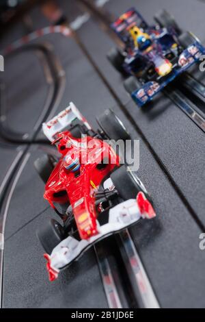 Modellformel eins Ferrari- und Redbull-Slot-Autos, die auf einer Scalextric-Strecke Rennen Stockfoto