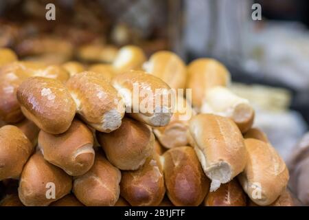 Frische Baguettes werden in einem Stapel übereinander angeordnet, vor einem verschwommenen Hintergrund. Der Markt, Jerusalem. Stockfoto