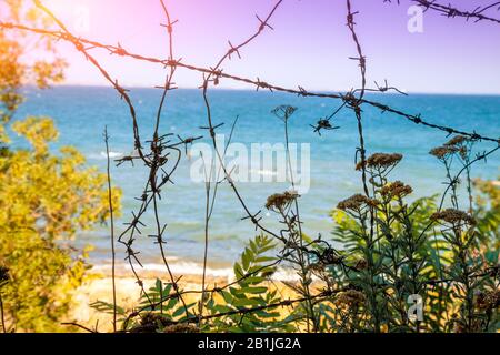 Stacheldraht gegen schönen Strand an einem sonnigen Tag Stockfoto