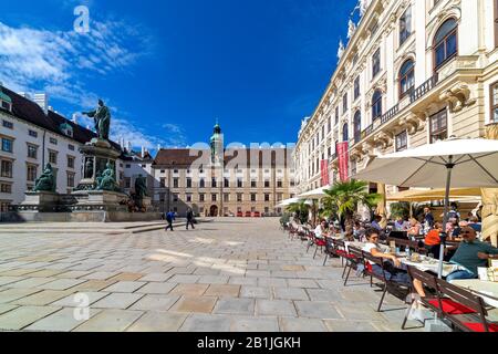 Personen, die im Außenrestaurant auf dem Innenhof der Hofburg sitzen - ehemaliges Kaiserpalais in Wien, Österreich. Stockfoto