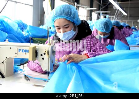 Chinesische Arbeiter nähen und fertigen am 26. Februar 2020 medizinische Schutzkleidung in einer Bekleidungsfabrik in Zaozhuang City, der ostchinesischen Provinz Shandong Stockfoto