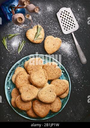 Käsekekse Rezeptfoto leerer Essenshintergrund mit Vintage-Spachtel und Rosmarin, auf Schiefersteinoberfläche. Platz für Text kopieren Stockfoto