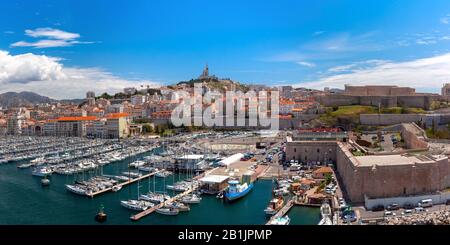 Der alte Hafen Vieux und die Basilika Notre Dame de la Garde im historischen Stadtzentrum von Marseille am sonnigen Tag, Frankreich Stockfoto