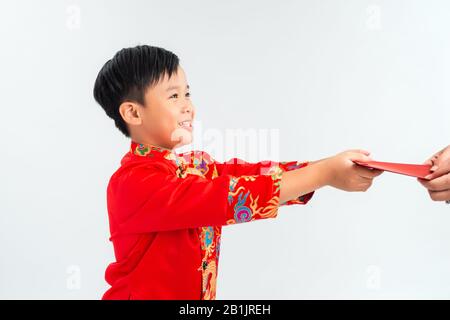 Kleiner vietnamesischer Junge, der rote Envelops für Tet hält. Das Wort bedeutet doppeltes Glück. Es ist das Geschenk in Lunar New Year oder Tet Holiday on Isolate Background Stockfoto