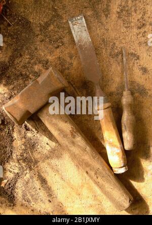 Alte rostige Holzwerkzeuge auf einem Holztisch. Hammer-Meißel und Schraubendreher Stockfoto