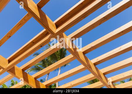 Sonnenschutzdachbaufragment unter blauem Himmel am sonnigen Sommertag. Holzbohlen Stockfoto