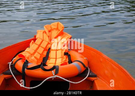 Outfit des Rettungsschwimmers auf dem Wasser im Sommerboot, Rettungsweste, Rettungsschwimmerjacke in orangefarbenem Farbton. Konzeptrettung auf dem Wasser im Sommer. Stockfoto