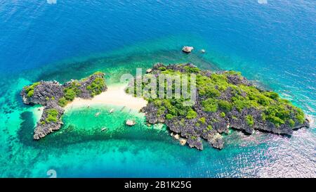 Luftaufnahme von der kleinen, isolierten tropischen Insel mit weißem Sandstrand und blauem, transparentem Wasser und Korallenriffen. Lahos Island, Caramoan-Inseln, Philippinen. Stockfoto