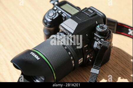 Wasserdichtes DSLR Pentax K3 Kameragehäuse mit 18-135 mm Objektivsatz auf Holztisch unter Sonneneinstrahlung Stockfoto