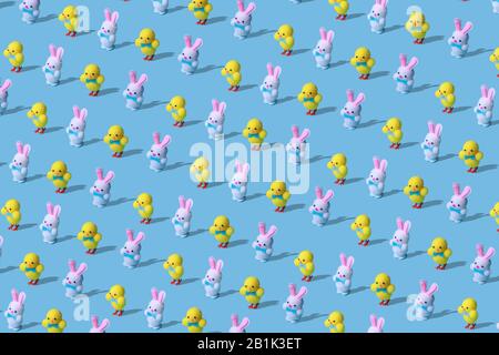 Modisches Ostermuster aus Hasen und Hühnerspielzeug auf blauem Hintergrund in minimalem Stil. Osterkonzept in minimalem Stil. Stockfoto