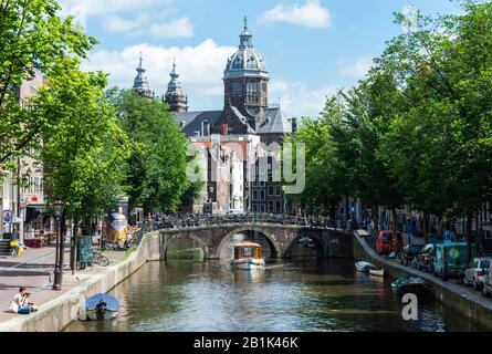 Amsterdam, Niederlande - 22. Juni 2016. Blick auf den Kanal Oudezijds Voorburgwal und die Straße im Amsterdamer Stadtteil De Wallen in Richtung der Basilika von Sain Stockfoto