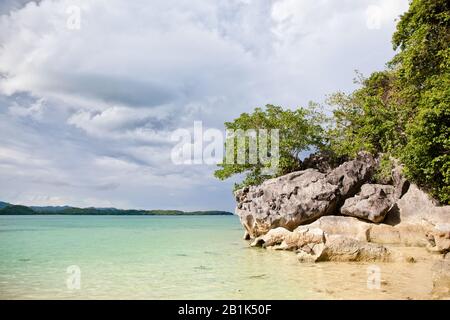 Große Kalkfelsen am Strand von Bagieng Island in der Gemeinde Caramoan, Provinz Camarines Sur, Luzon auf den Philippinen. Sommer- und Urlaubskonzept. Stockfoto