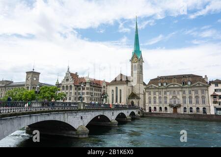 Zürich, Schweiz - 25. Juni 2016. Blick auf die Brücke von Munsterbrucke und die Fraumunster Kirche in Zürich mit den umliegenden historischen Gebäuden und Menschen. Stockfoto