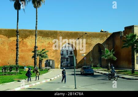 Rabat, Marokko - 18. November 2014: Nicht identifizierte Menschen und Stadtmauer mit Durchgangsstraße Stockfoto