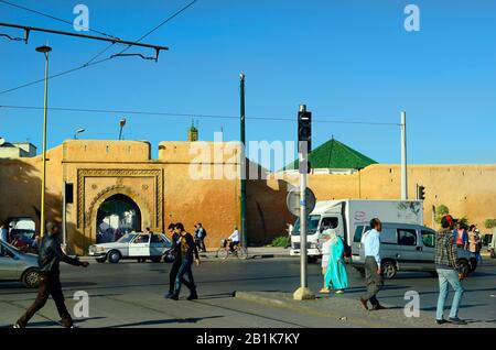 Rabat, Marokko - 18. November 2014: Nicht identifizierte Menschen vor der mittelalterlichen Stadtmauer mit Tor und Autos Stockfoto