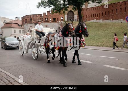 Krakow, Polen - 6. August 2018: Zwei Pferde Im Altmodischen Coach Am Altstädter Ring Im Trübem Sommertag. Die alte, mittelalterliche Stadt Krakow ist als unes aufgeführt Stockfoto