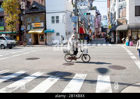 Osaka japan - november8.2018: Unidentifizierter Mann, der ein Fahrrad mit chirurgischer Maske auf der straßenstadt osaka trägt Stockfoto