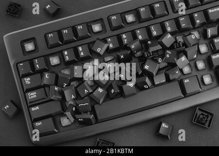 Heap der entfernten Tasten von einer Tastatur, die auf der Tastatur liegt. Schwarzweiß. Nahaufnahme. Stockfoto