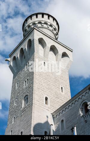 Füssen, Deutschland - 29. Juni 2016. Turm der Schlossanlage Schloss Neuschwanstein im Dorf Hohenschwangau bei Füssen, mit Bergen im Hintergrund. Stockfoto