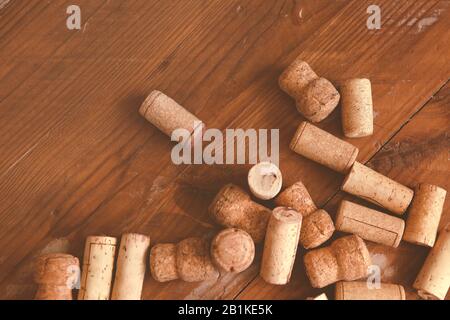 Draufsicht auf den Haufen verschiedener Wein- und Champagnerflaschenkorken auf Holzgrund Stockfoto