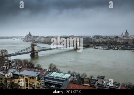 Kettenbrücke über die Donau in Budapest mit der Stephansbasilika und dem ungarischen Parlament in Budapest an einem regnerischen Wintertag Stockfoto