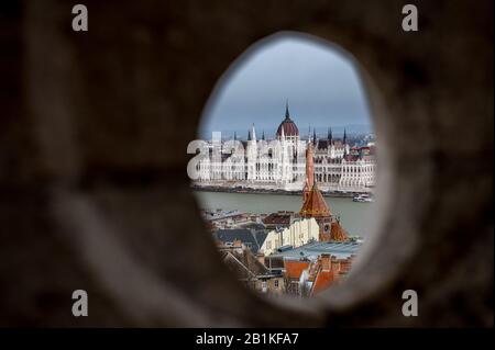 Schauen Sie durch ein Loch in der Fischerbastion auf dem Buda Castle Hill, Budapest mit dem ungarischen Parlamentsgebäude Stockfoto