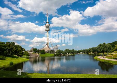 München, Deutschland - 1. Juli 2016. Blick auf den Olympiaturm über den Olympiasee im Olympiapark in München, Deutschland, an einem sonnigen Sommertag, Stockfoto