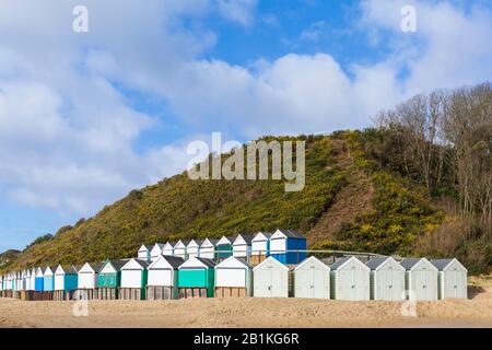 Strandhütten in Middle Chine mit Strandpromenade, die im Sand aus dem jüngsten schlechten Wetter in Bournemouth, Dorset UK, an einem sonnigen kalten Tag im Februar bedeckt ist Stockfoto