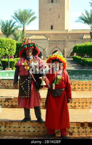 Marrakesch, Marokko - 23. November 2014: Nicht identifizierter Wasserträger in ihrer traditionellen Tracht mit Ausrüstung vor der Koutoubia-Moschee Stockfoto