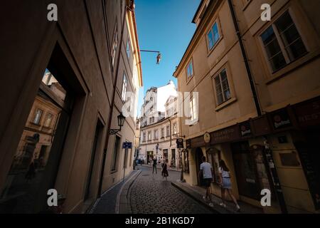 Prag, Tschechien - 10.08.2019. Die Architektur der Prager Altstadt. Alte Gebäude, gemütliche Straßen. Mann hängend aus, ein Kunstwerk von David Cerny Stockfoto