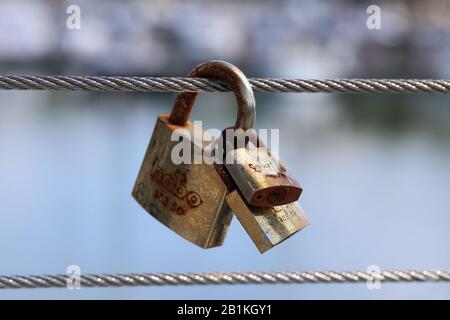 Lovelocks hängt an einem Draht einer Fußgängerbrücke in Haukilahti/Haukilahdenranta, Espoo, Finnland, Juli 2019. Symbole der Liebe und der Ehe. Stockfoto