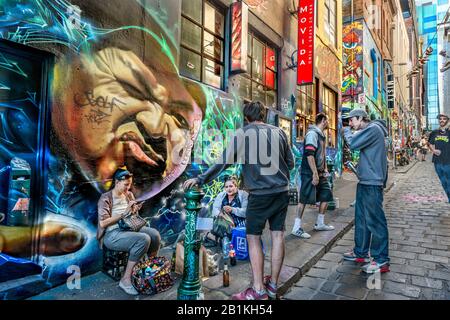 Junge Leute und Graffiti-Künstler, die zusammen auf dem gepflasterten Gasse Way, der Hosier Street, Melbourne Lanes, Melbourne, Victoria, Australien hängen Stockfoto