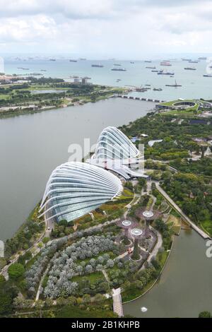 Luftaufnahme des "Blumendoms" in den Gärten an der Bucht, des "Wolkenwaldes" und darüber hinaus zum Staudenfeuer und den Schiffen vor Marina South, Singapur, Asien Stockfoto