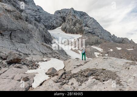 Wanderer blickt auf alpine Landschaft, Schneelochgletscher, Niederes Kreuz, Dachstein, Salzkammergut, Oberösterreich, Österreich Stockfoto