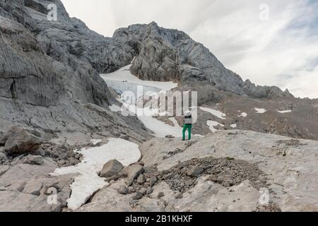 Wanderer blickt auf alpine Landschaft, Schneelochgletscher, Niederes Kreuz, Dachstein, Salzkammergut, Oberösterreich, Österreich Stockfoto