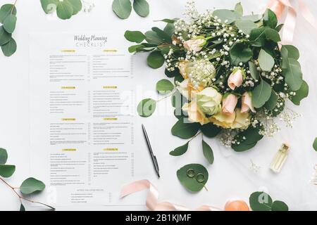 Brautblumen und Notizen in, um Liste auf weißem Hintergrund zu machen Stockfoto