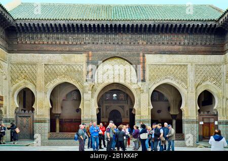 Fez, Marokko - 20. November 2014: Unidentifizierte Gruppe von Touristen im Innenhof von Medersa Bou Inania - einer islamschule Stockfoto