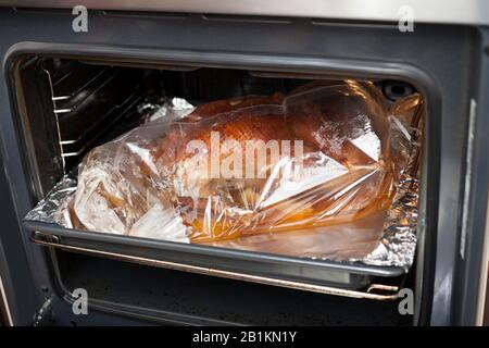 Gebackene Ente. Im Backofen mit knackiger Schärfe. Auf einem Backblech liegend. Im Ärmel zum Backen. Stockfoto