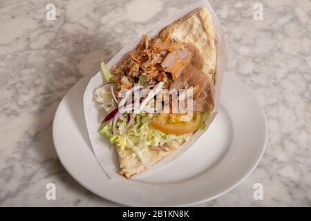 Donner Kebab serviert auf dem Teller auf dem Marmortisch. Typische Speisen aus Istanbul Stockfoto