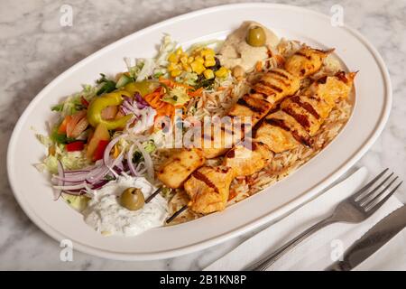 Teller mit türkischen Speisen Sish Tavuk, Hummusfries und Salat. Stockfoto