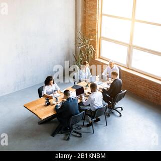 Geschäftsleute Sitzen Am Schreibtisch Im Modernen Büro In High Angle Stockfoto