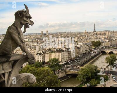 Blick auf die Pariser Stadtlandschaft, einschließlich Eiffelturm und seine, von einem der Türme von Notre-Dame, mit einem Gargoyle im Vordergrund Stockfoto